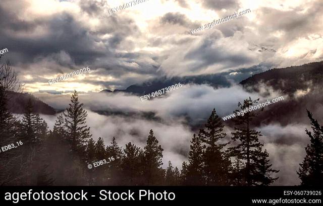 Dramatic Scenic Nature Panoramic View of Canadian Mountain Landscape covered in clouds. Artistic Render. Located near Squamish and Whistler, British Columbia