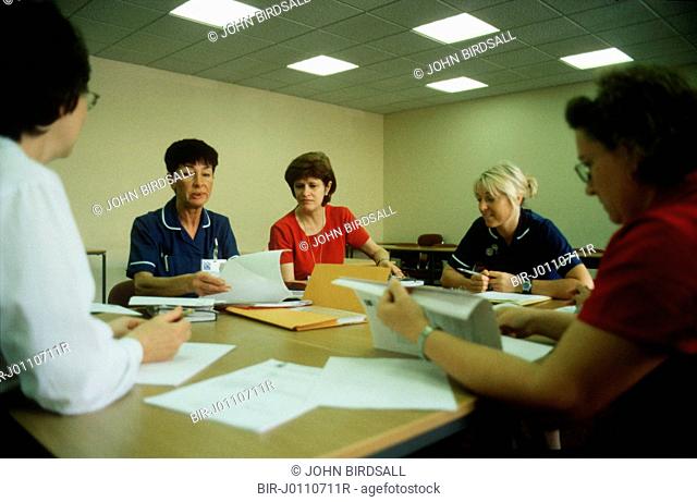 Various health workers sitting around table undergoing staff development training at the Queens Medical Centre, Nottingham