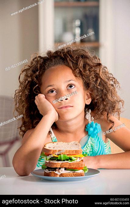 Girl staring upwards with sandwich