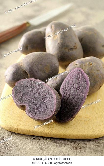 Purple potatoes on a wooden board