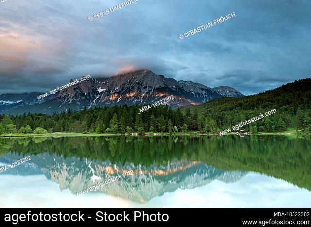 The Lautersee near Mittenwald reflects the Karwendel at cloudy sunset