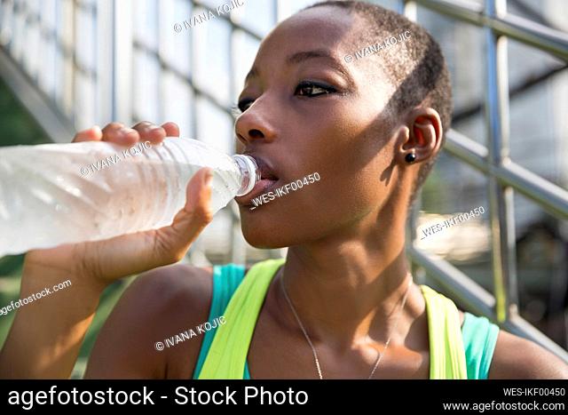 Contemplative woman drinking water from bottle
