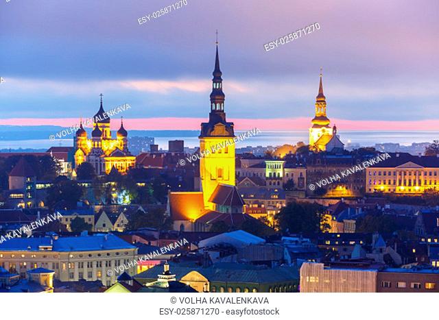 Aerial cityscape with Medieval Old Town illuminated in evening twilight and City Hall, St. Olaf Baptist Church and Alexander Nevsky Cathedral in Tallinn