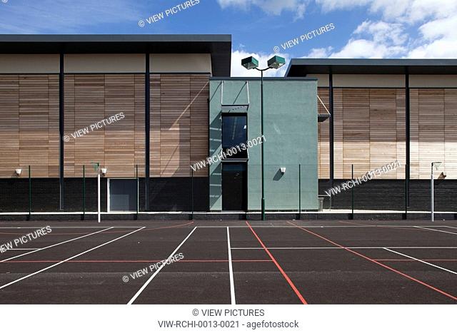 Trinity School Sports Hall, Newbury, United Kingdom. Architect ADP Architects Ltd, 2012. View across all weather sports pitch of sports hall south elevation