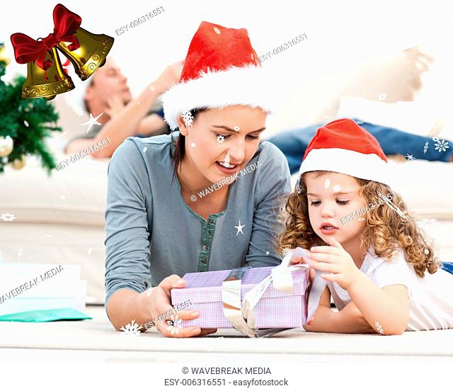 Mother and daughter unwrapping a present lying on the floor