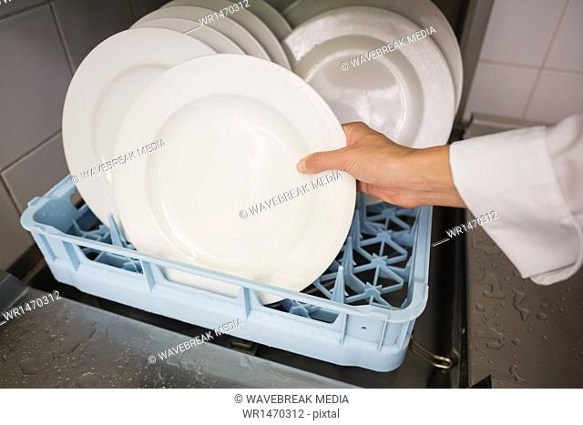 Chef putting plates in drying rack