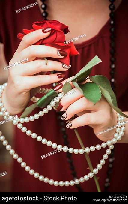 Women's hands in retro style with necklaces and rose