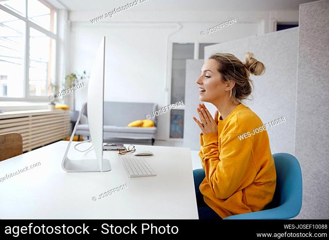 Businesswoman on video call through desktop PC at home