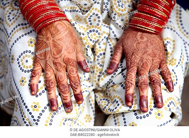 Indian woman's hands decorated with mehndi, red henna tattoos, Varanasi, India