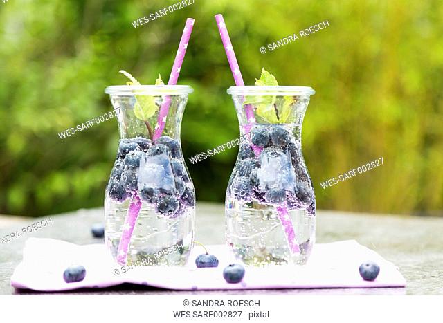 Two carafes of infused water with blueberries and mint