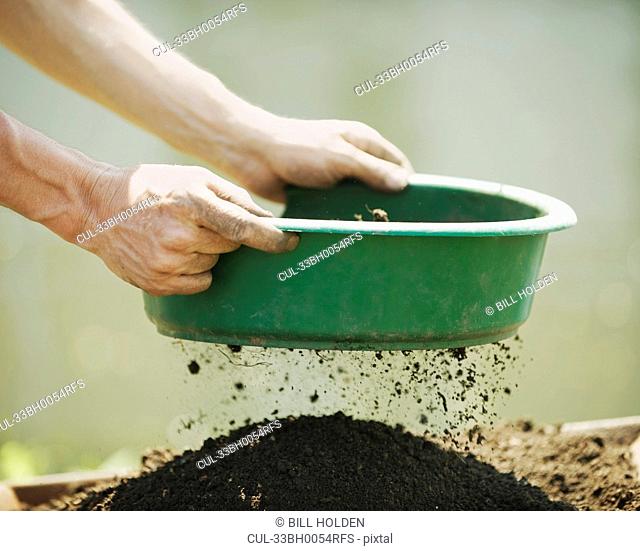 Hands sifting soil outdoors