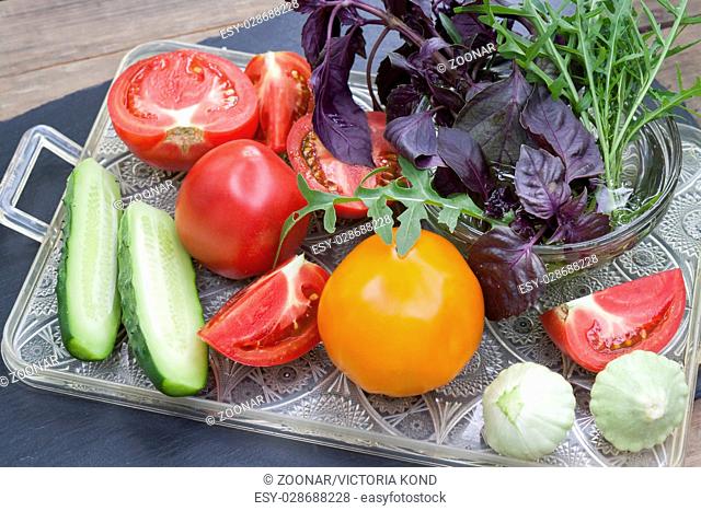 Different ripe organic vegetables and fresh herbs on a tray