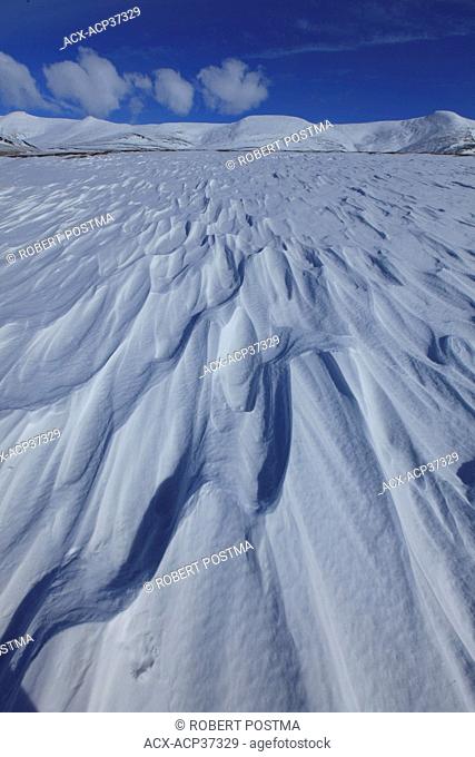 Drifts carved by the winds along the Dempster Highway, with the Richardson Mounatins are in the distance, Yukon Territory, Canada