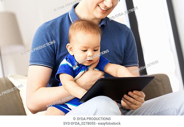 happy father and baby son with tablet pc at home