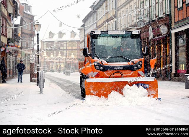 03 January 2021, Saxony-Anhalt, Wernigerode: A snow removal vehicle drives through the streets of the city. Snow fell across large parts of the country on...