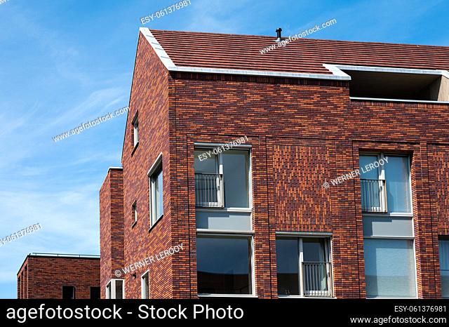 Groningen, The Netherlands - Brick stone facades of residential houses in old town against blue sky