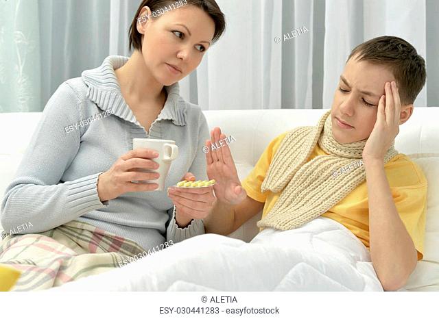 worried Young mother and il son in bed