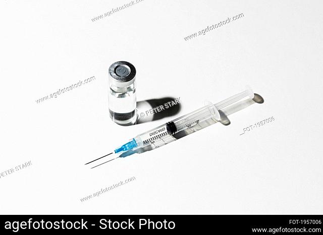 COVID-19 vaccine vial and syringe on white background