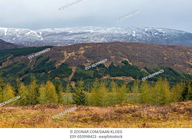 Mountains with snow and Dark clouds near Loch Loyne in the Highlands of Scotland with lake, snow and piles of stone, image Daan Kloeg, Commee