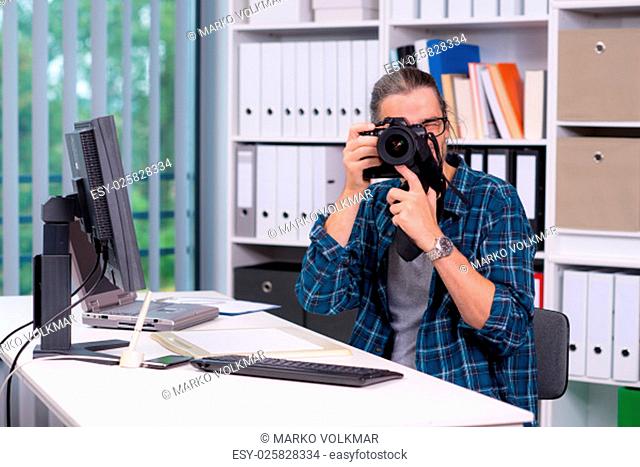creative man with camera is working in his office