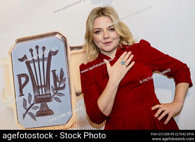 08 December 2023, Lower Saxony, Hahnenklee: Singer Annett Louisan has her photo taken with the Paul Lincke Ring before the award ceremony