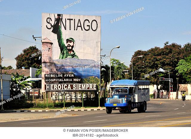 Vintage lorry driving in front of revolutionary propaganda poster, Santiago siempre heróica, Spanish for Santiago is always heroic, Plaza de la Revolucion
