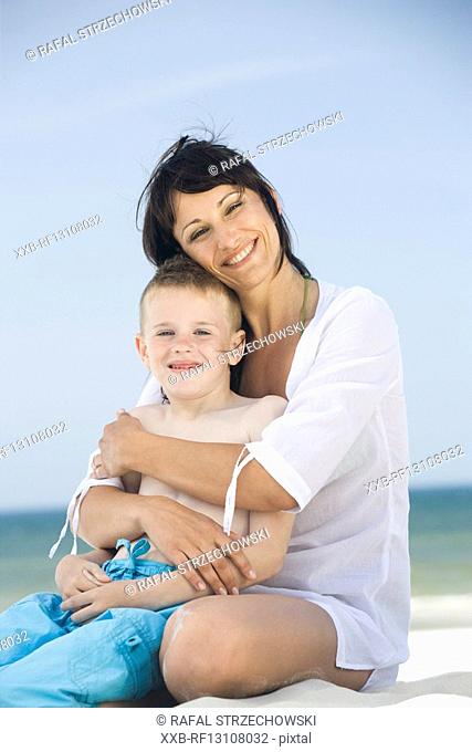 mother with son playing on beach