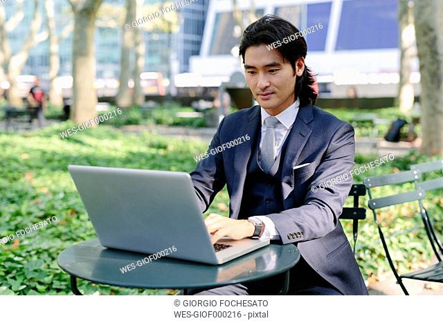 USA, New York City, Manhattan, businessman working with a laptop in Bryant Park
