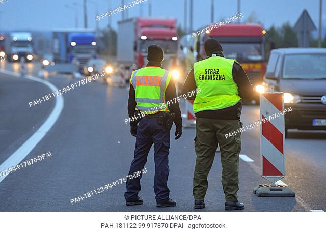 22 November 2018, Poland, Swiecko: A federal policeman and a Polish border guard stand at the A12 motorway at the former border crossing in Swiecko and observe...