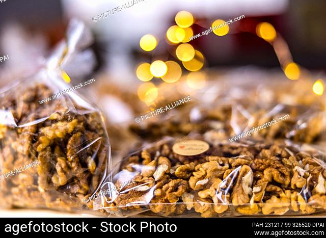 16 December 2023, Brandenburg, Leuthen: Packaged walnuts lie on a stall at a small Advent market. Advent and Christmas markets are also held in many German...