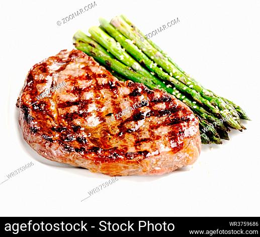 Barbecue grilled beef steak meat with asparagus on white plate close up