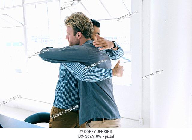 Business people hugging at meeting