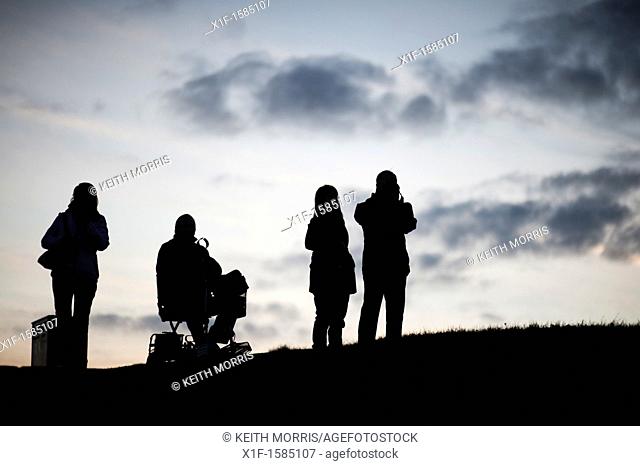 Four people, one in a wheelchair, silhouetted against the sky, Aberystwyth at dusk, October 2011