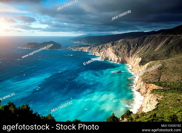 Dreamy atmosphere on picturesque jagged coastline of Kefalonia. Overcast weather, deep clouds, stormy sea and sunlight, Cephalonia, Ionian islands, Greece