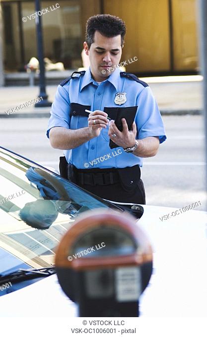 Policeman writing parking ticket
