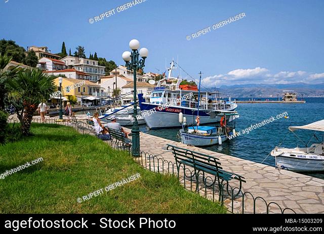 Kassiopi, Corfu, Greece, fishing boats and an excursion boat in the harbor of Kassiopi, a small port town in the northeast of the Greek island of Corfu