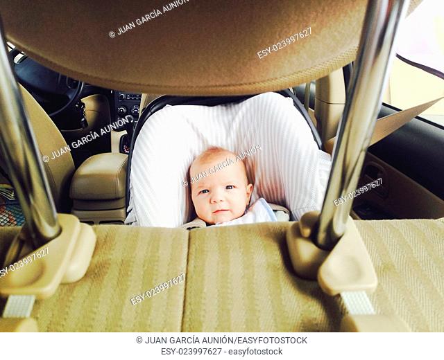 4 months old baby boy in a safety car seat. Picture taken from headrest