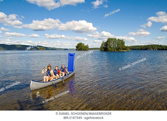 Family canoeing on a lake near Bengtsfors, Dalsland, Sweden, Europe