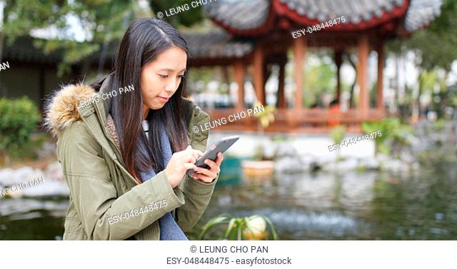 Woman use of mobile phone at china, woman wearing winter jacket at outdoor