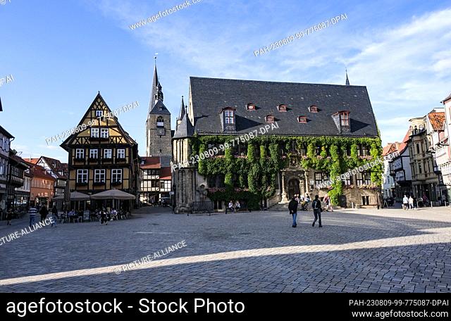 04 August 2023, Saxony-Anhalt, Quedlinburg: The market square of Quedlinburg with the listed residential building Hoken 1 (l-r), the market church St
