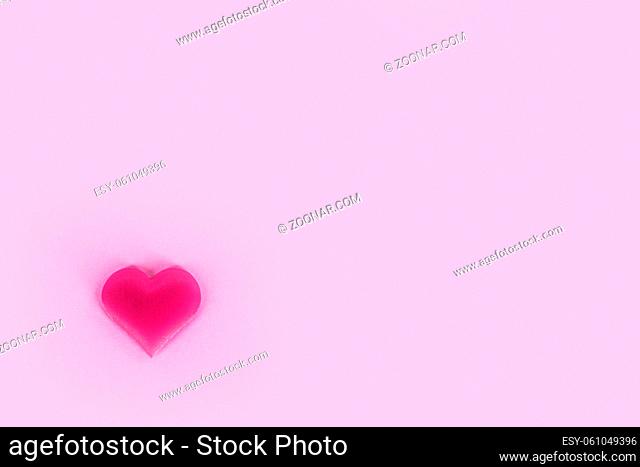 Valentine's day silk heart on pink paper background, love concept