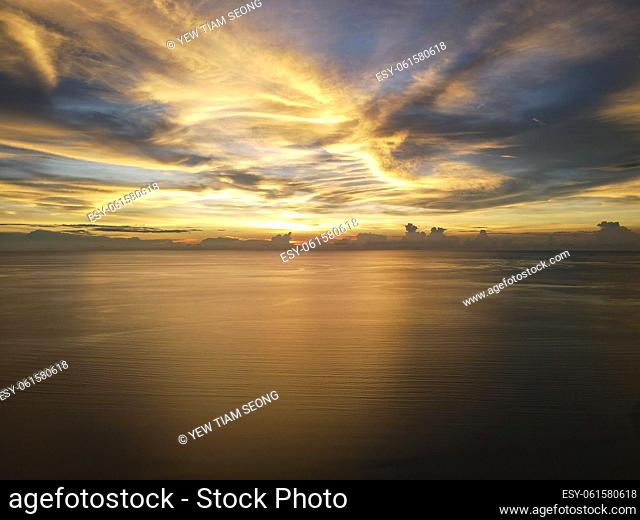 Aerial dramatic orange cloud sunset reflection at sea