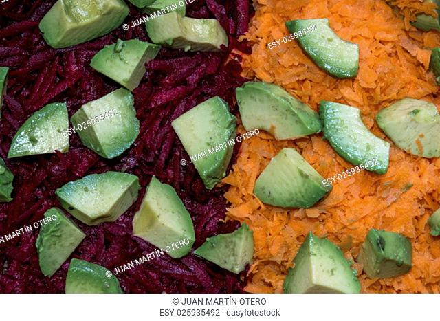 closeup of raw salad with carrot, avocado and beetroot