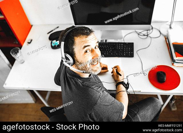 Man sitting on desk with headset working at home