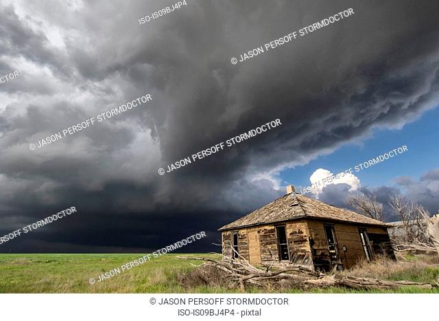 Intense sunshine and severe thunderstorm, barn in foreground, Cope, Colorado, US