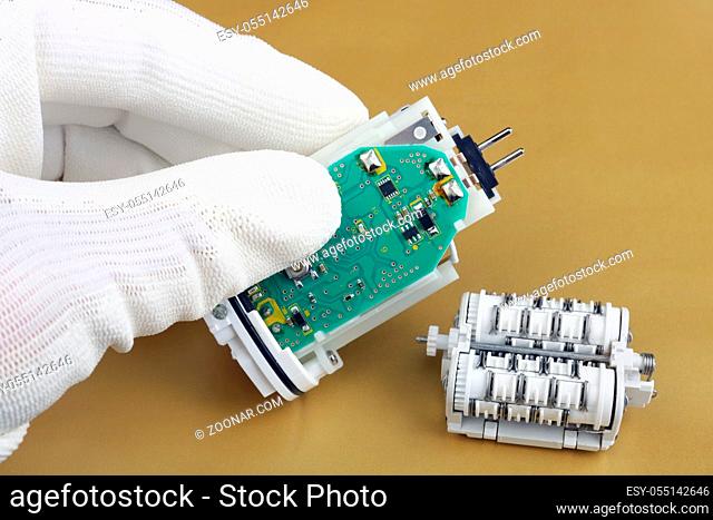 Technician repair the used epilator- electro mechanical device with battery and motor. Macc production. Studio macro concept