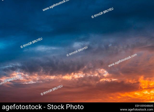 Bright And Dark Dramatic Sky Before Thunder. Cloudscape Background With Clouds At Sunset Or Sunrise In Warm And Cold Colors