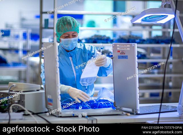 PRODUCTION - 24 October 2023, Mecklenburg-Western Pomerania, Teterow: Dorit Hoffmann checks the tightness of a tube set in which patient cells are modified into...