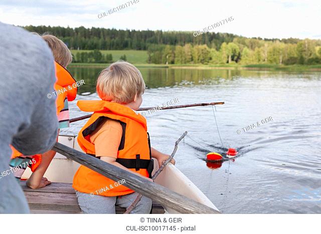 Adult sailing with boys on boat in lake, Finland