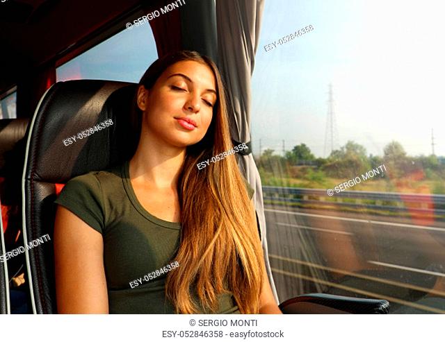 Young beautiful woman sleeping sitting in the bus. Bus passenger traveling sitting in a seat and sleeping